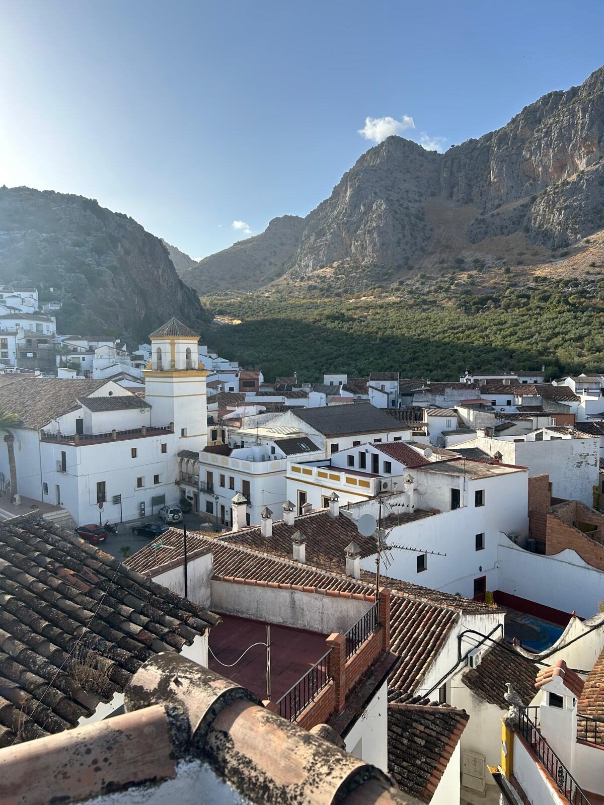 Vista de día del pueblo blanco, el campanario y las montañas