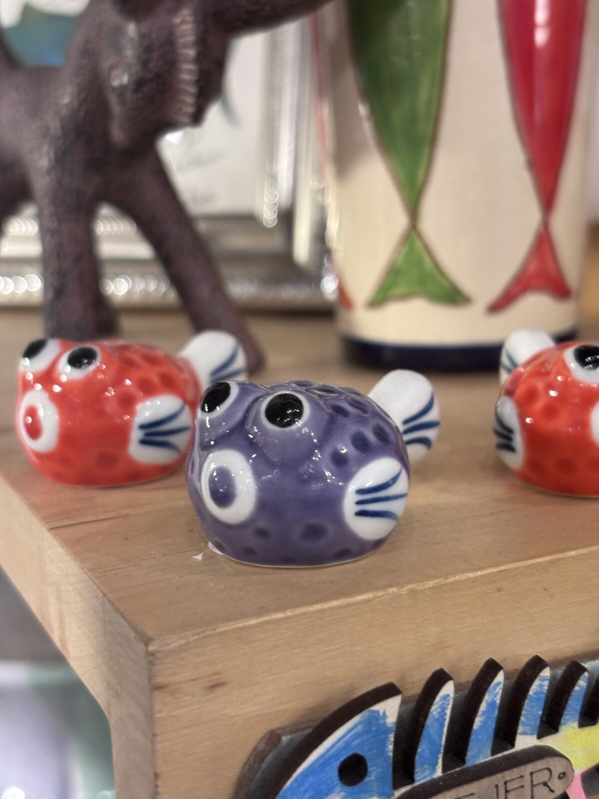Peces de cerámica de colores en una estantería